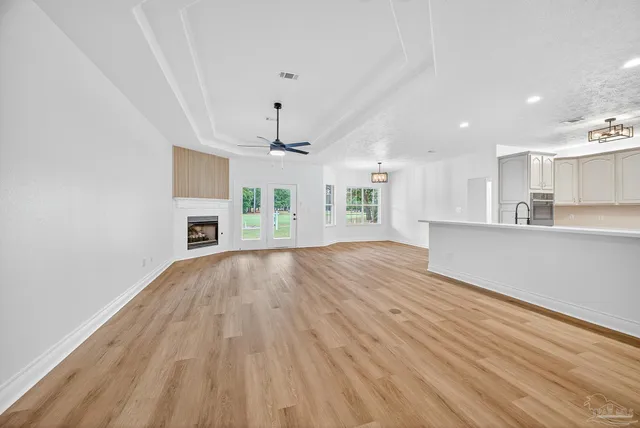 a view of a kitchen with a sink dishwasher a refrigerator with wooden floor and a cabinet