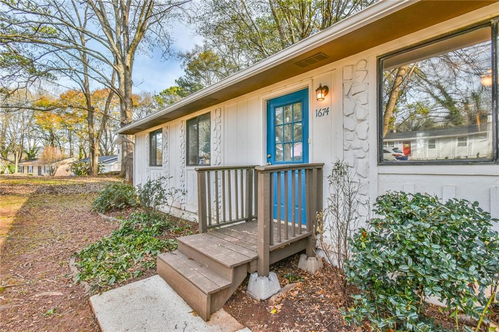 a view of a house with a small deck and a garden