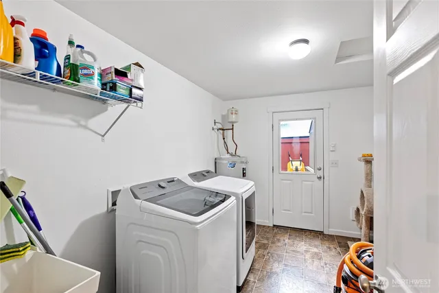 a utility room with dryer washer and a view of living room