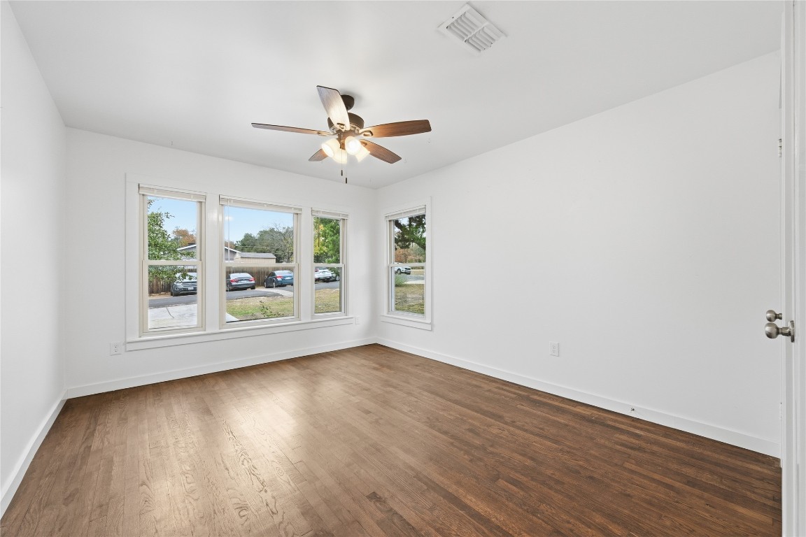 1003 Cogbill Street, Unit 1 Austin, TX 78745 - Photo 12 of 15 an empty room with wooden floor chandelier fan and windows