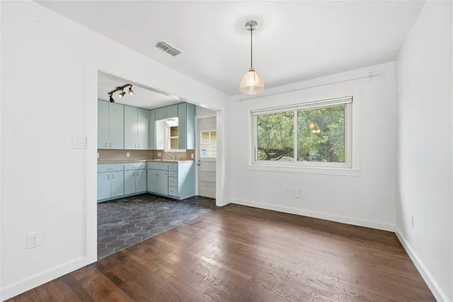 a view of a kitchen with a sink dishwasher and wooden floor
