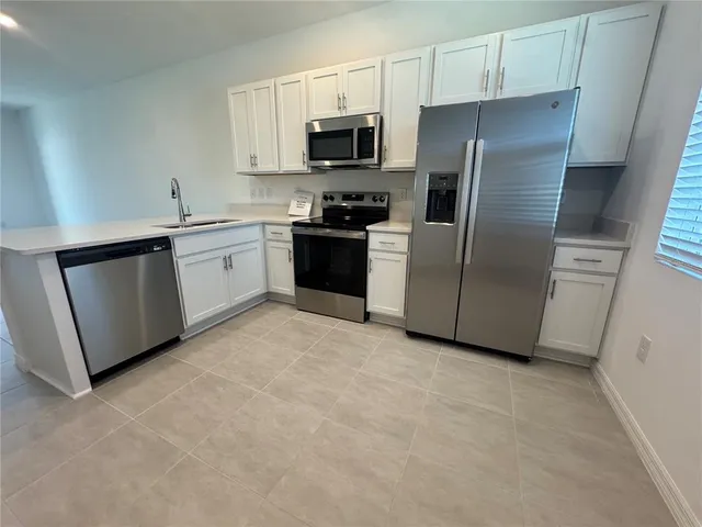 a kitchen with stainless steel appliances a refrigerator sink and microwave