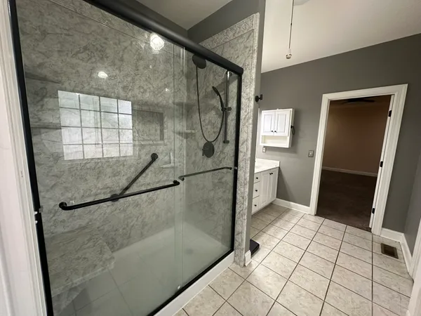 a bathroom with a glass shower door and a mirror