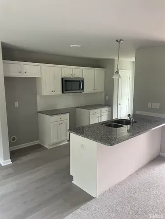 a kitchen with stainless steel appliances granite countertop a sink a stove a refrigerator and cabinets