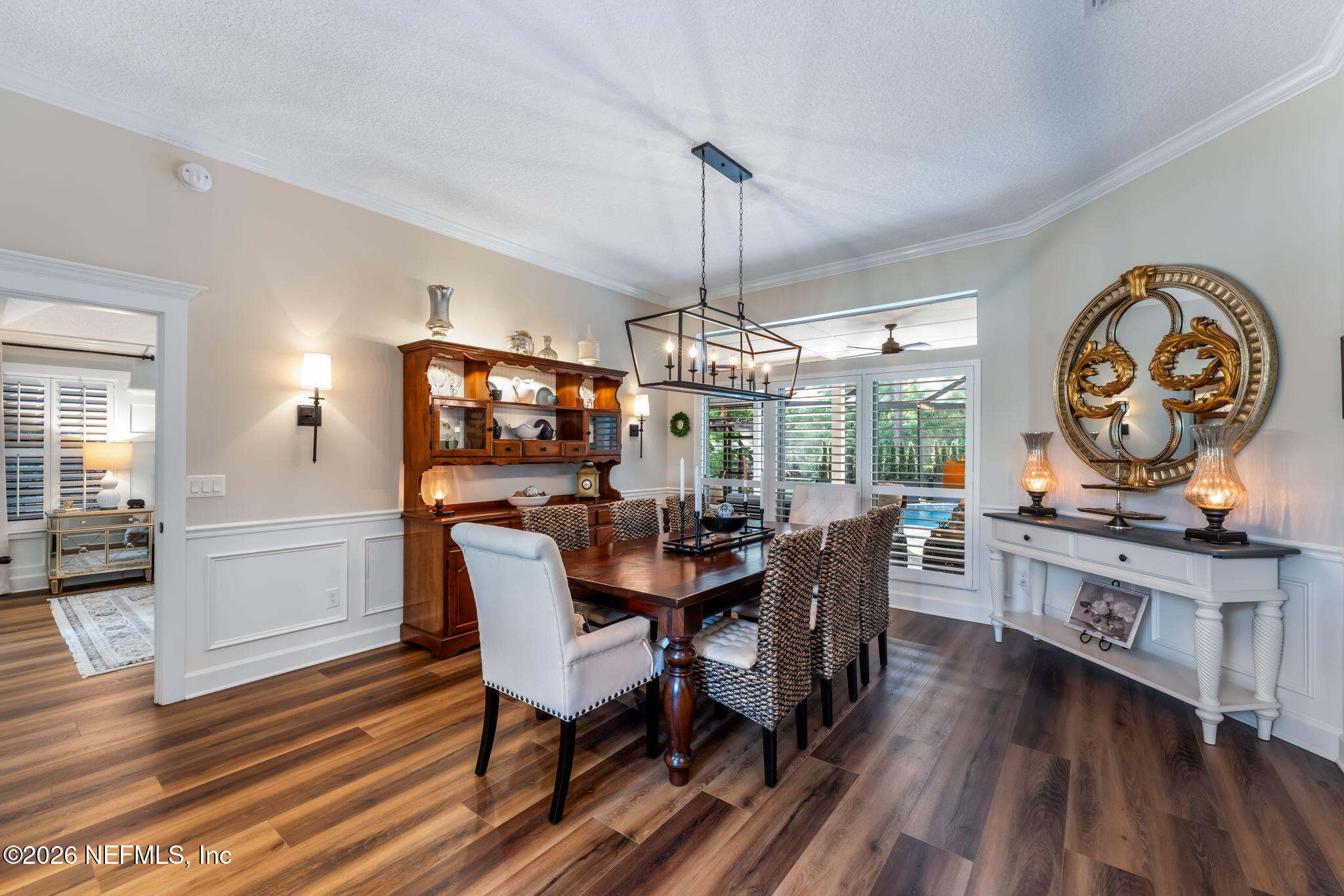 1204 Creek Bend Road St. Johns, FL 32259 - Photo 15 of 107 a dining room with wooden floor a chandelier a wooden table and chairs