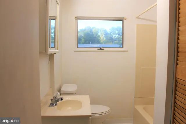 a bathroom with a sink mirror and toilet