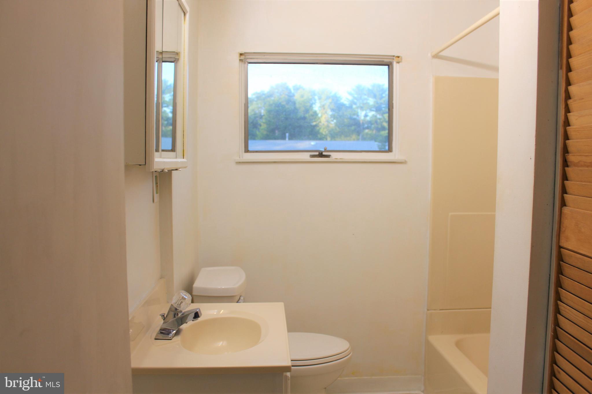413 Dickinson Road Glassboro, NJ 08028 - Photo 13 of 16 a bathroom with a sink mirror and toilet