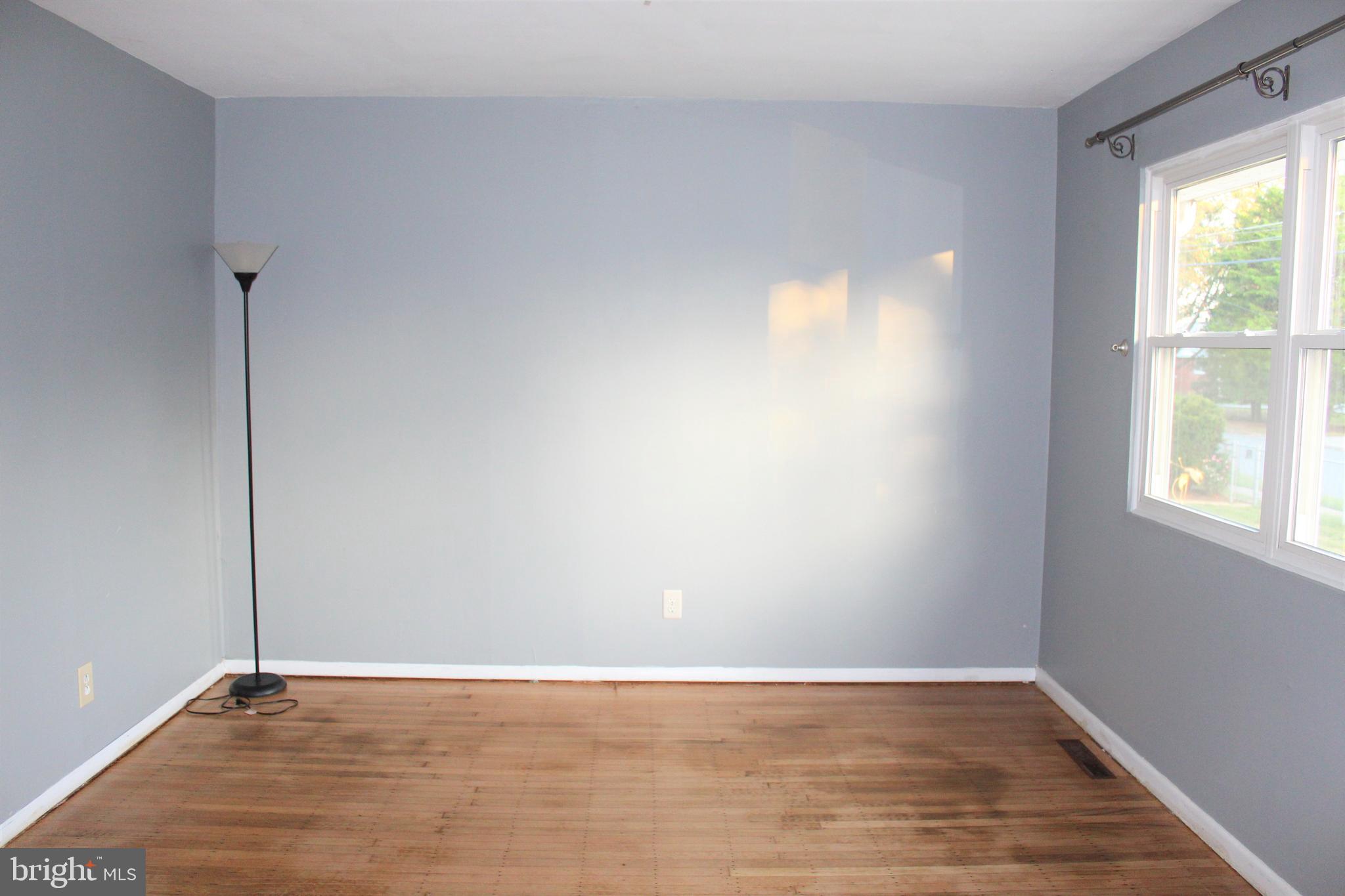 413 Dickinson Road Glassboro, NJ 08028 - Photo 5 of 16 a view of an empty room with wooden floor and a window