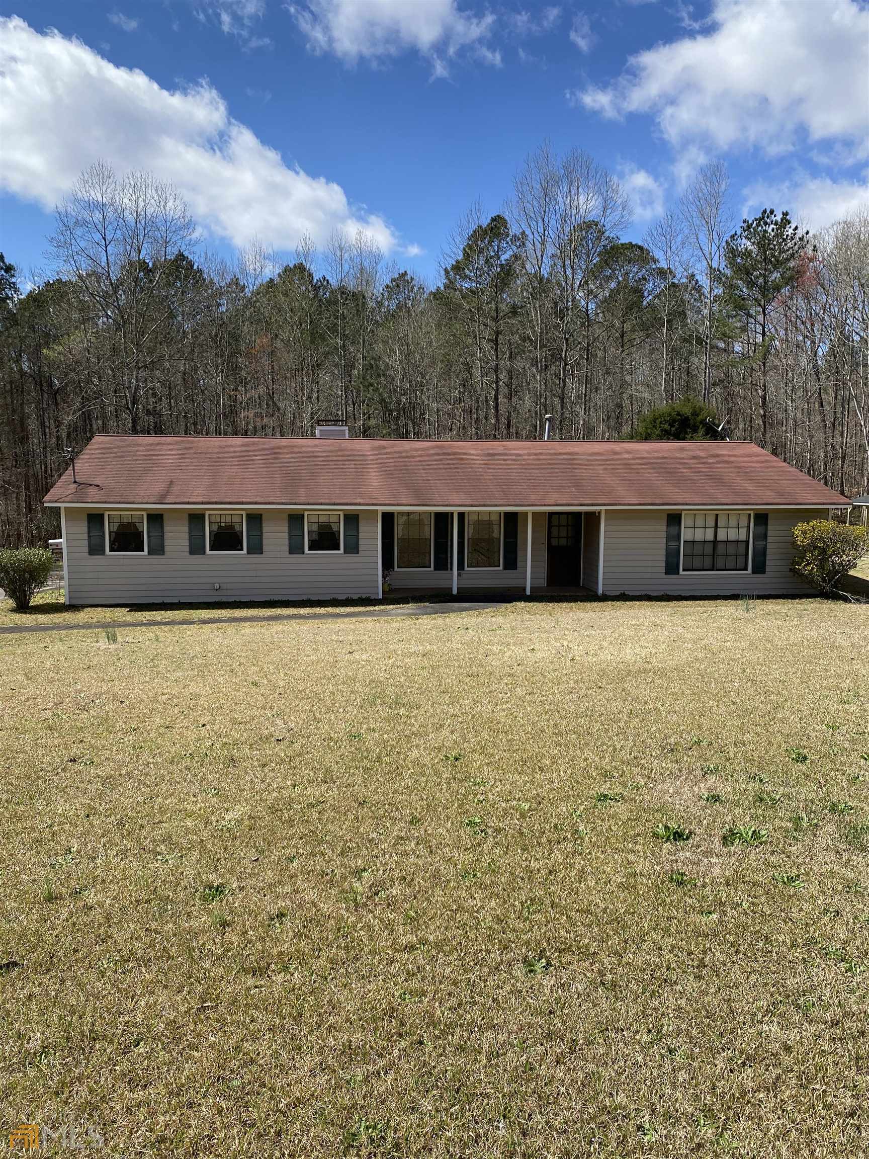 5565 Short Road South Fulton, GA 30213 - Photo 1 of 1 a view of a large pool with lawn chairs under an umbrella