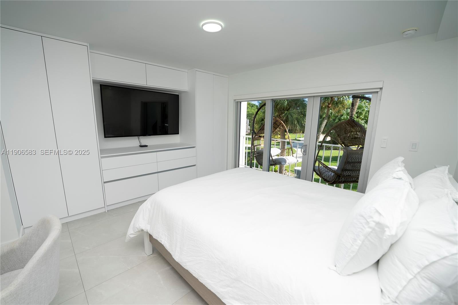 881 Ocean Drive, Unit TH15 Key Biscayne, FL 33149 - Photo 7 of 26 a bedroom with a large bed and a flat screen tv