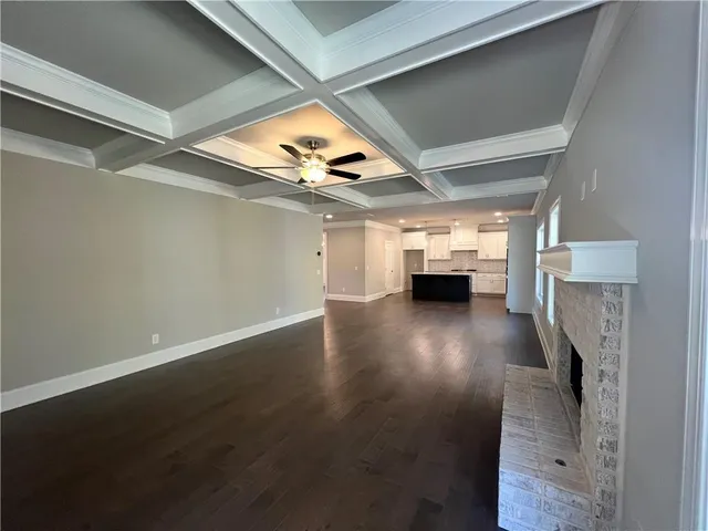 a view of empty room with fireplace and wooden floor