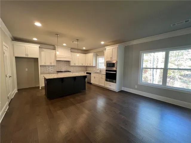 a kitchen with granite countertop a stove and a refrigerator