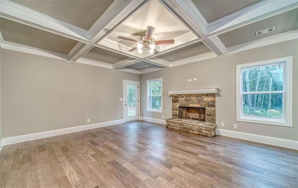 514 Adventure Trail Jefferson, GA 30549 - Photo 17 of 49 an empty room with windows fireplace and wooden floor