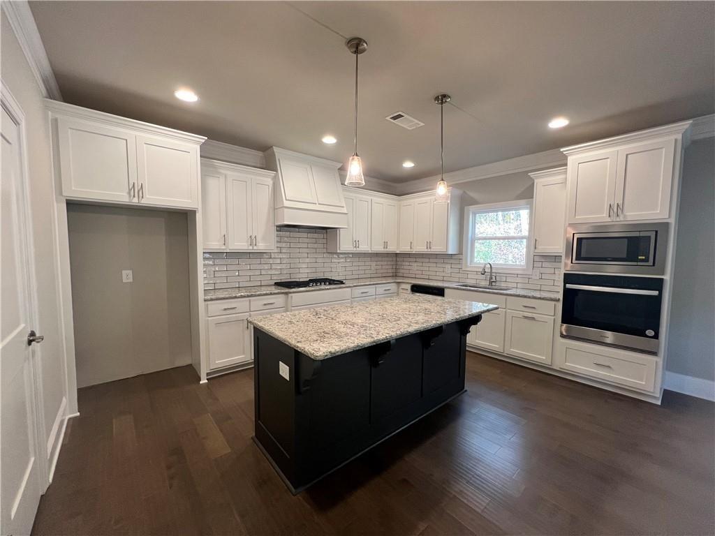 514 Adventure Trail Jefferson, GA 30549 - Photo 18 of 48 a kitchen with granite countertop a stove and a refrigerator