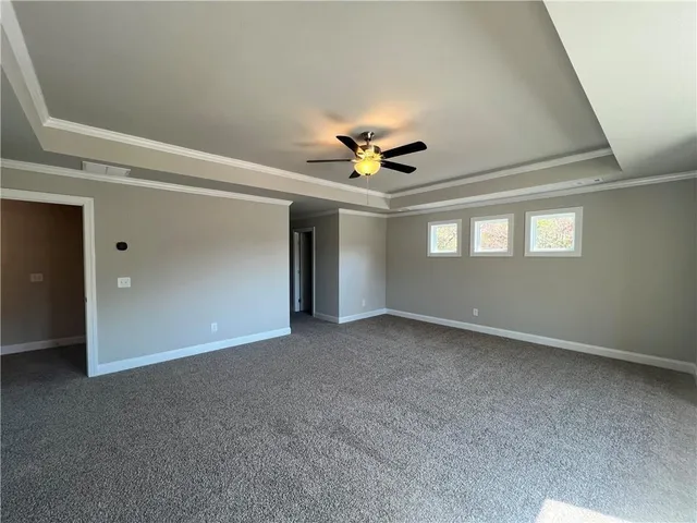 an empty room with windows and chandelier fan