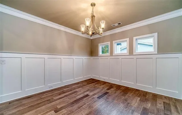 a view of a room with wooden floor staircase and a kitchen space