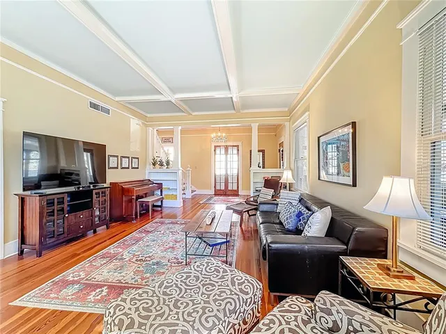 a kitchen with stainless steel appliances granite countertop a stove top oven a sink a dining table and chairs with wooden floor