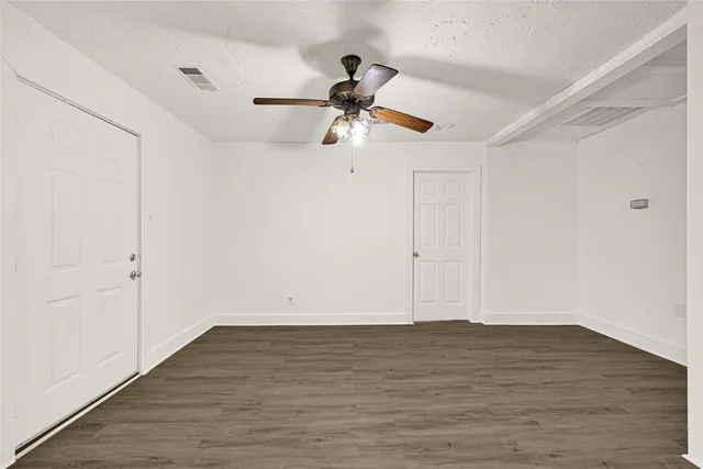 a view of a room with wooden floor and white walls