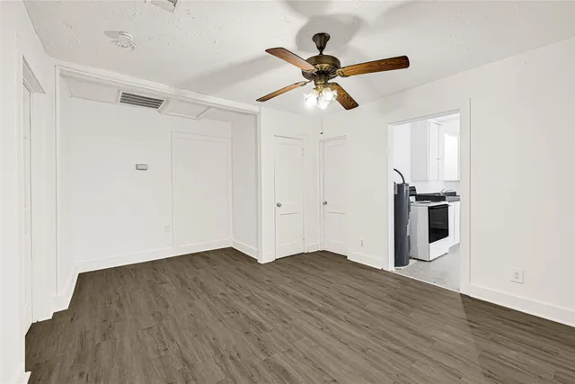 a view of a big room with wooden floor closet ceiling fan and windows