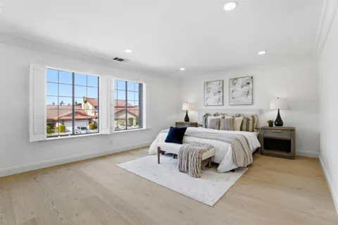 a kitchen with white cabinets and wooden floor