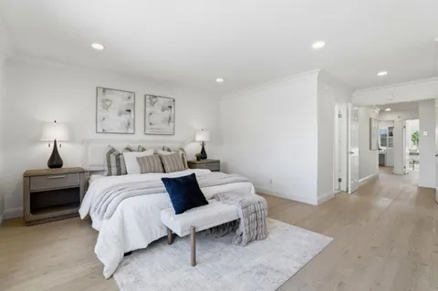 a bedroom with a bed and a painting on the wall