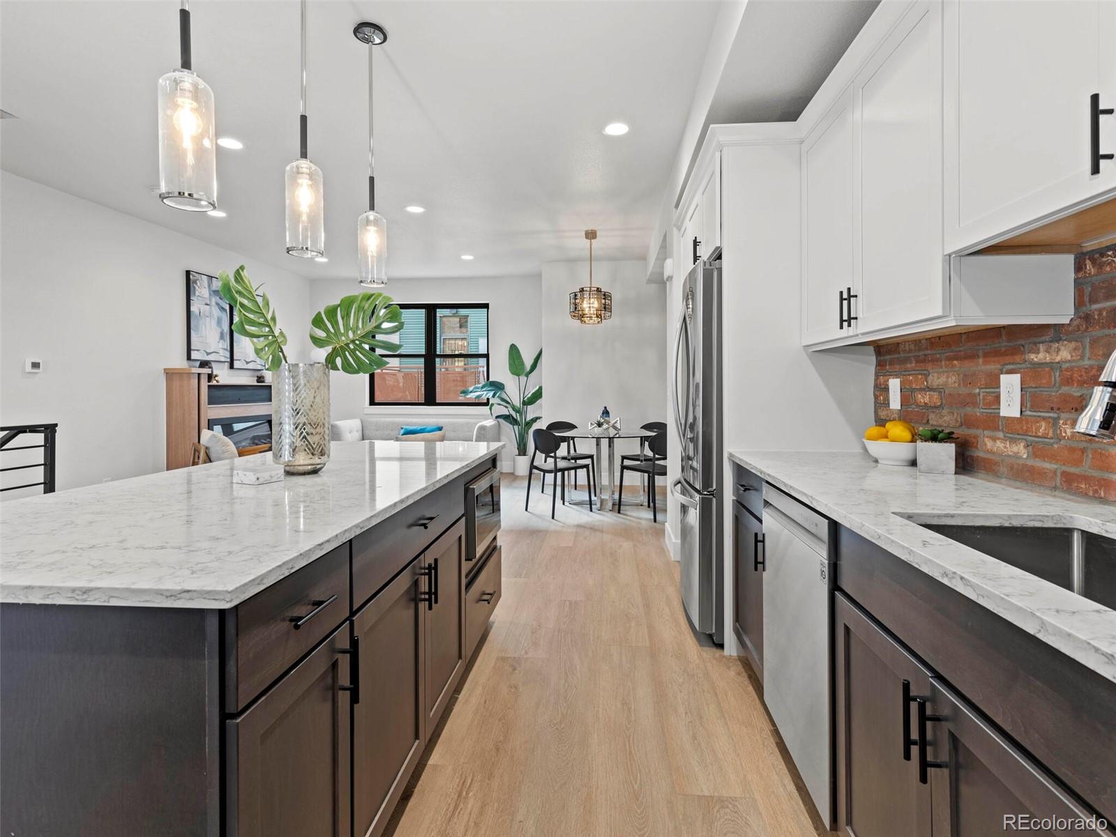5423 South Prince Street, Unit B Littleton, CO 80120 - Photo 15 of 40 a kitchen with kitchen island a counter top space a sink stainless steel appliances and cabinets