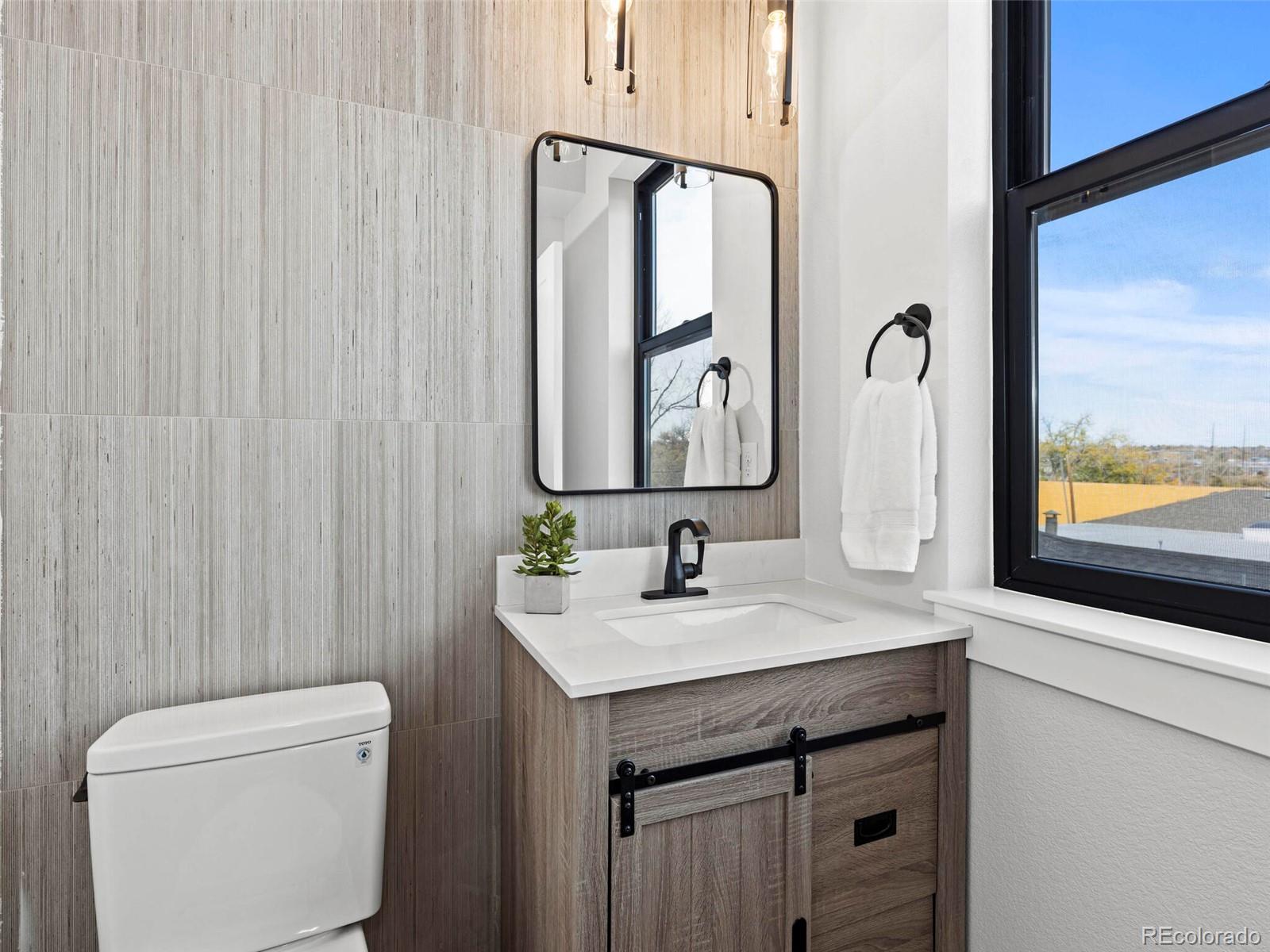 5423 South Prince Street, Unit B Littleton, CO 80120 - Photo 19 of 40 a bathroom with a toilet sink and mirror