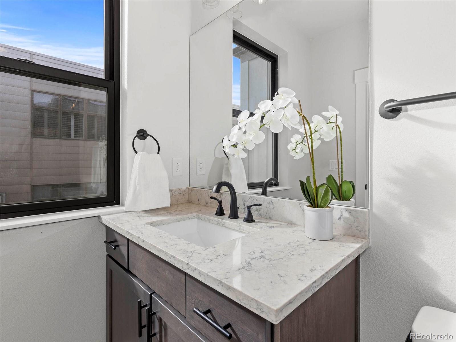 5423 South Prince Street, Unit B Littleton, CO 80120 - Photo 24 of 40 a bathroom with a sink a vanity and a mirror