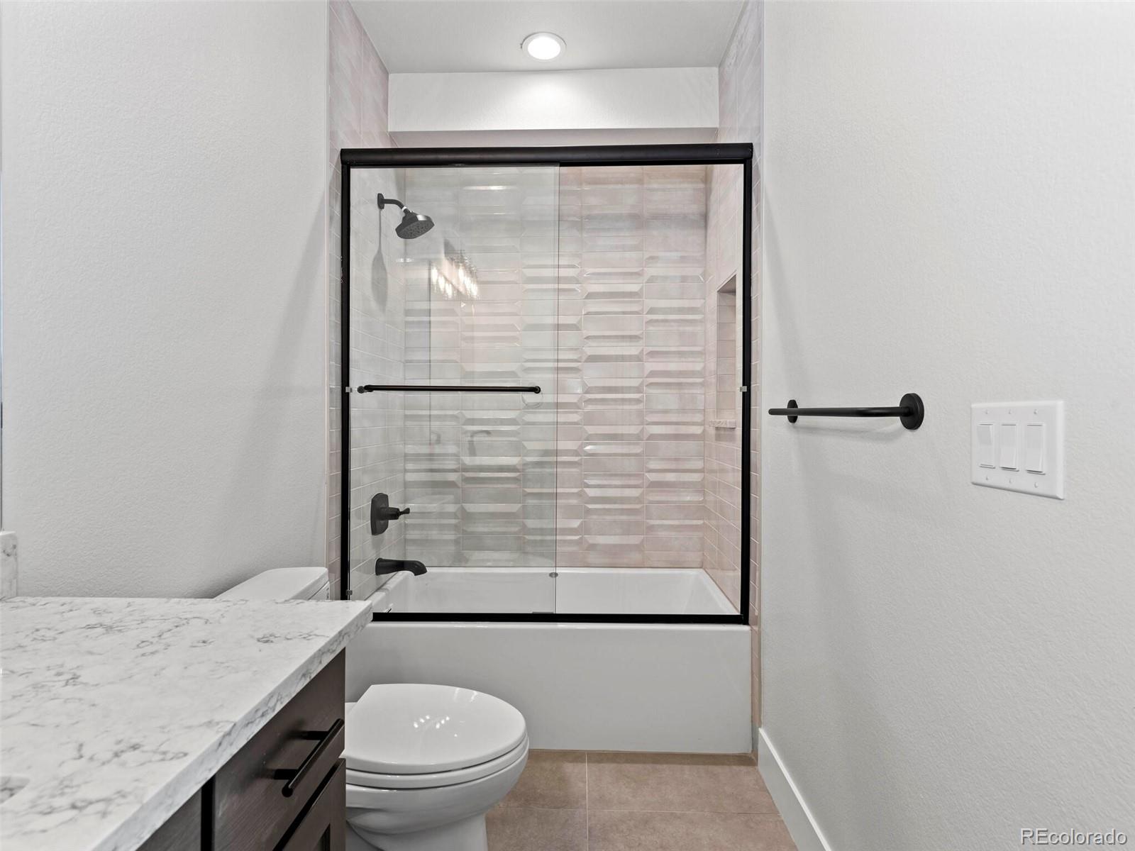 5423 South Prince Street, Unit B Littleton, CO 80120 - Photo 29 of 40 a bathroom with a granite countertop sink toilet and shower