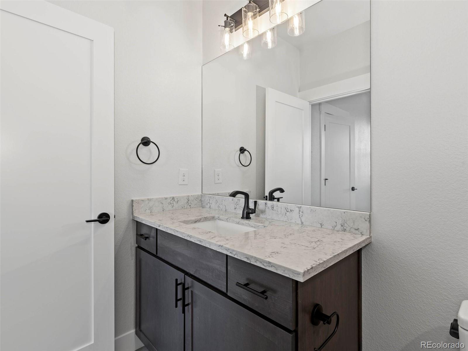 5423 South Prince Street, Unit B Littleton, CO 80120 - Photo 30 of 40 a bathroom with a granite countertop sink and a mirror