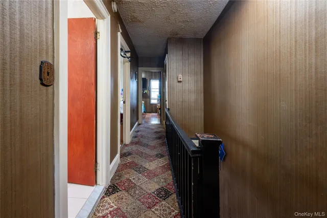 a hallway with front door and wooden stairs