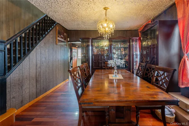 a dining room with furniture a chandelier and wooden floor