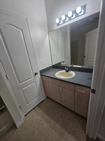 a bathroom with a granite countertop sink a mirror and a vanity