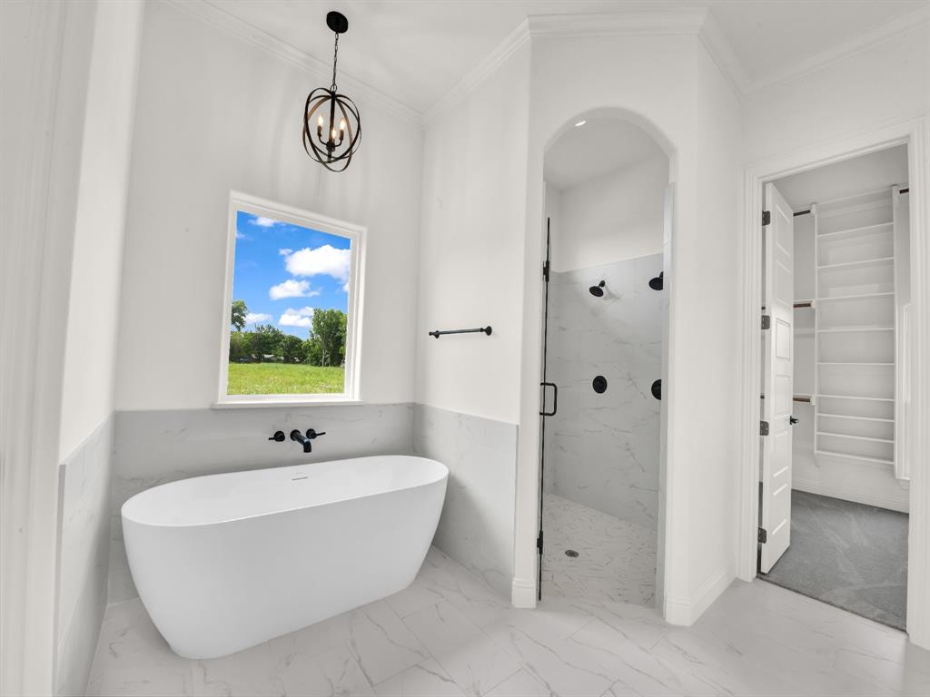 143 Desperado Way Weatherford, TX 76088 - Photo 23 of 36 Bathroom with marble finish floors, a marble finish shower, a freestanding tub, ornamental molding, and a chandelier