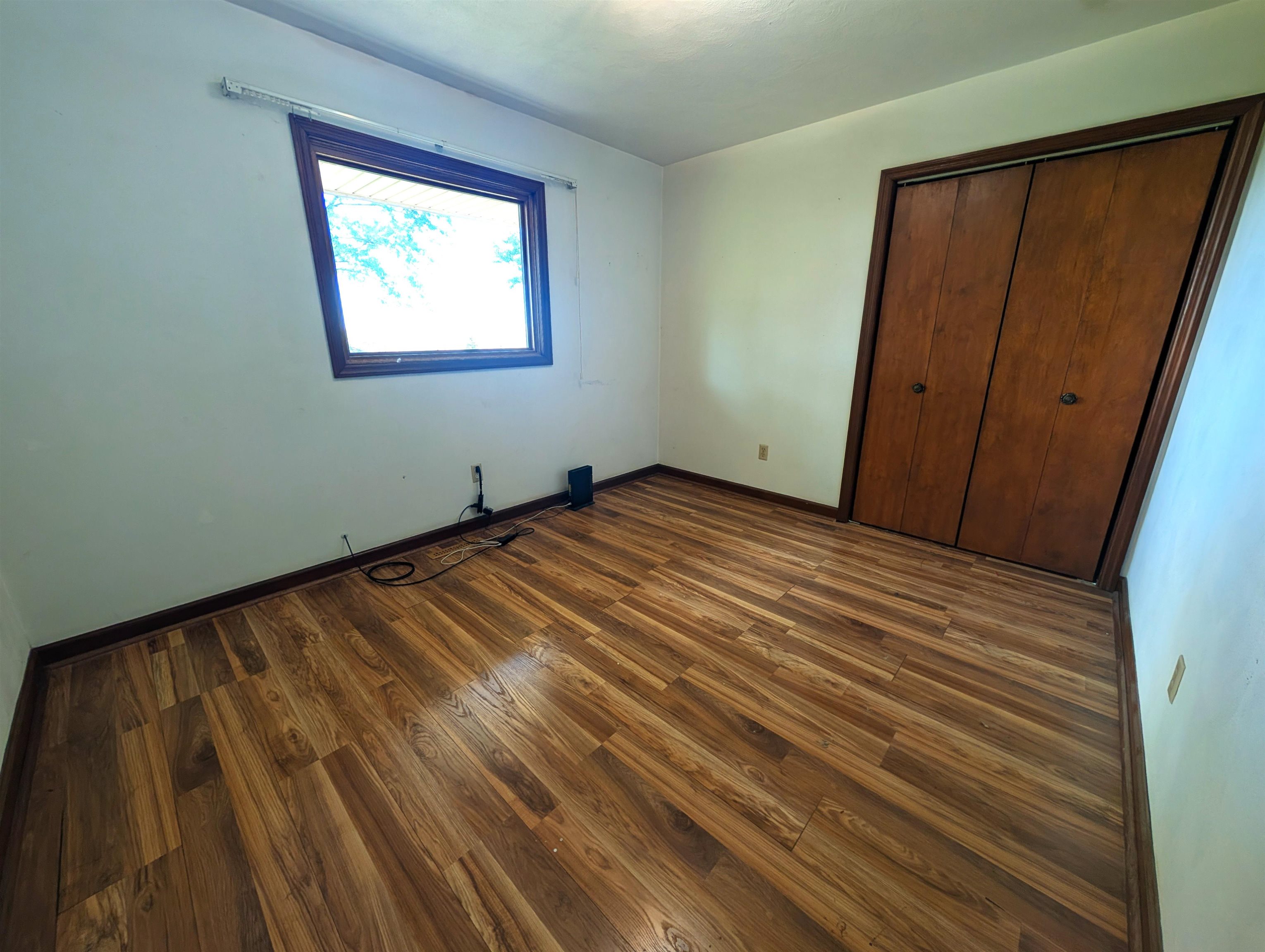10740 North Barker Road Byron, IL 61010 - Photo 11 of 21 a view of an empty room with wooden floor and a window