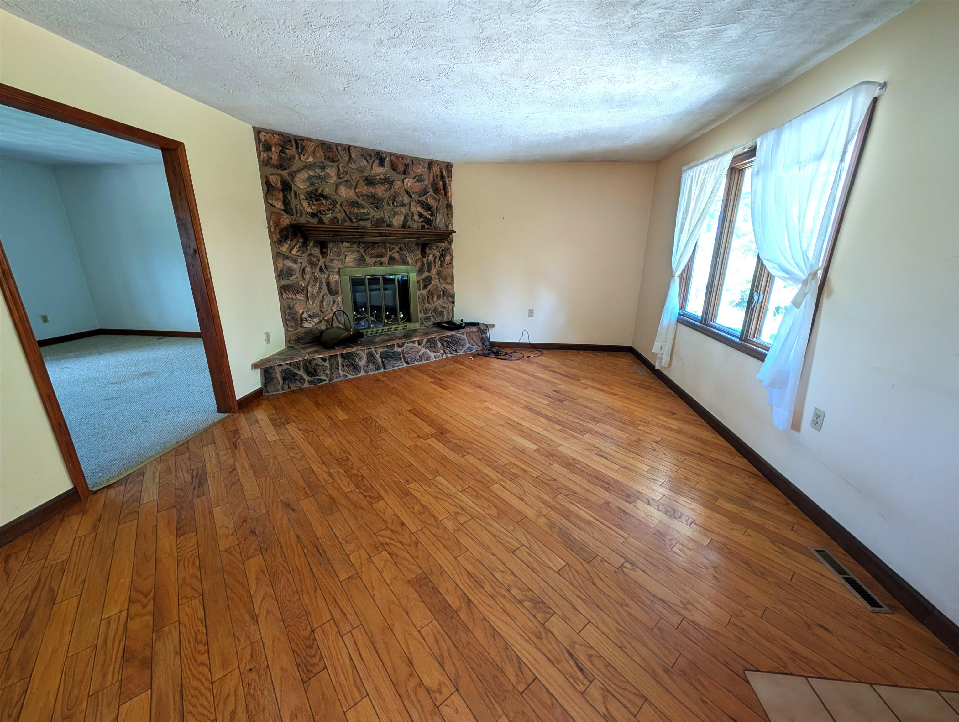 10740 North Barker Road Byron, IL 61010 - Photo 3 of 21 a view of an empty room with wooden floor and a window