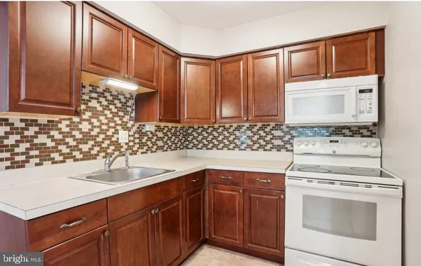a kitchen with granite countertop a sink stove and cabinets