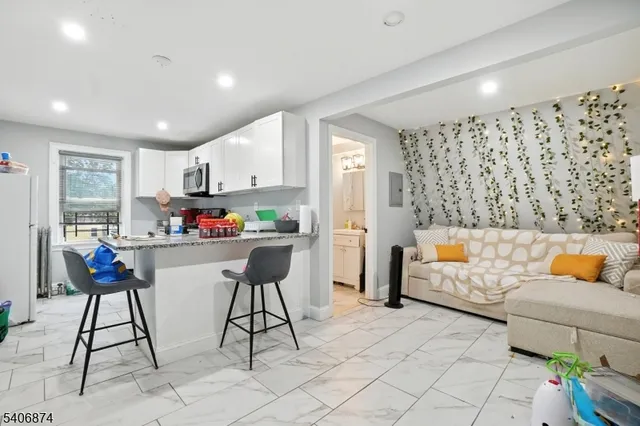 a kitchen with stainless steel appliances kitchen island granite countertop a refrigerator and a dining table