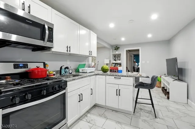a kitchen with a stove cabinets and chairs