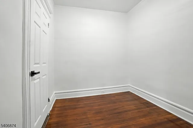a view of a room with wooden floor and white walls