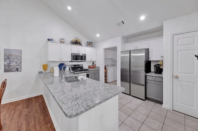 a kitchen with stainless steel appliances granite countertop a refrigerator and a sink