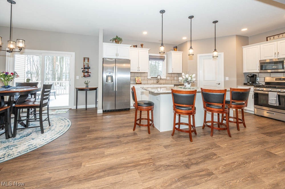 6580 Abbey Road North Canfield, OH 44406 - Photo 10 of 32 Kitchen featuring appliances with stainless steel finishes, pendant lighting, a kitchen island, white cabinets, and a breakfast bar