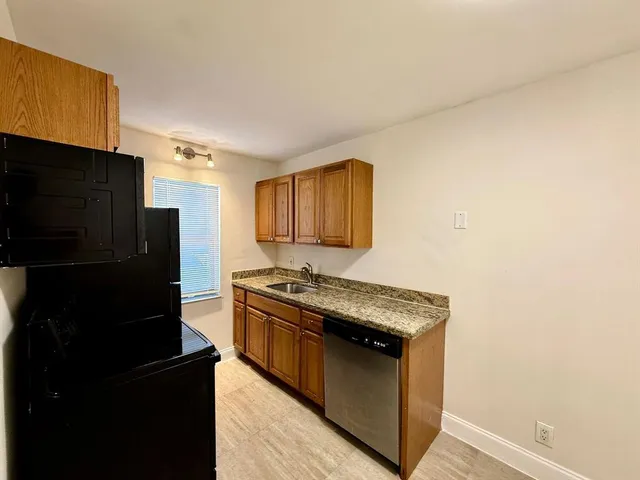 a kitchen with stainless steel appliances granite countertop a refrigerator and a stove
