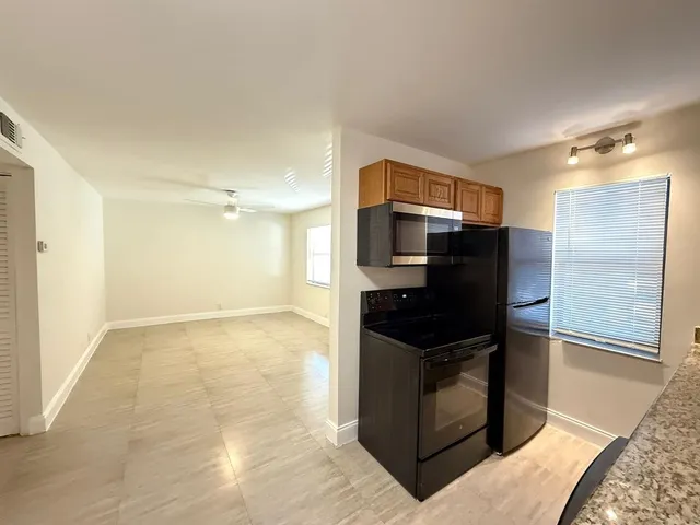 a kitchen with granite countertop a refrigerator and a stove