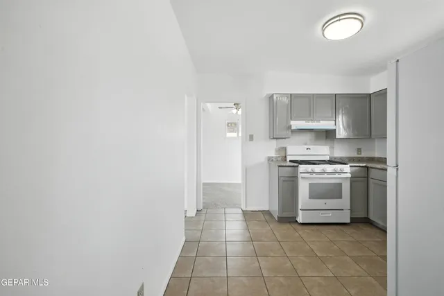 a kitchen with a stove top oven and cabinets
