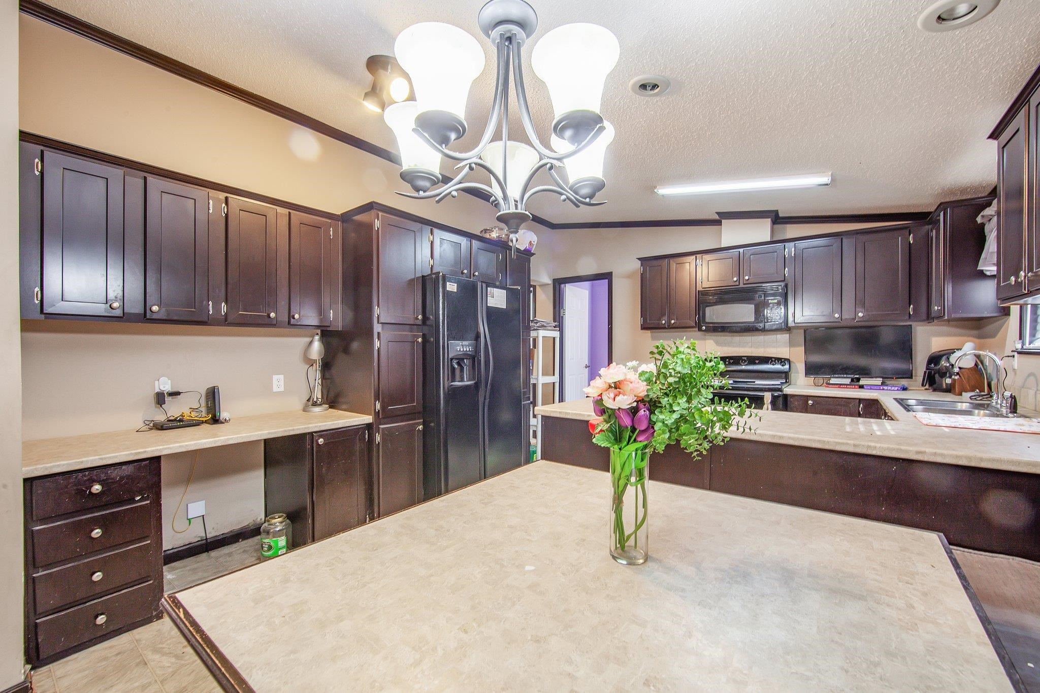 1040 River Road Bolivar, TN 38008 - Photo 18 of 27 a kitchen with stainless steel appliances kitchen island granite countertop a refrigerator a stove a sink dishwasher and white cabinets with wooden floor
