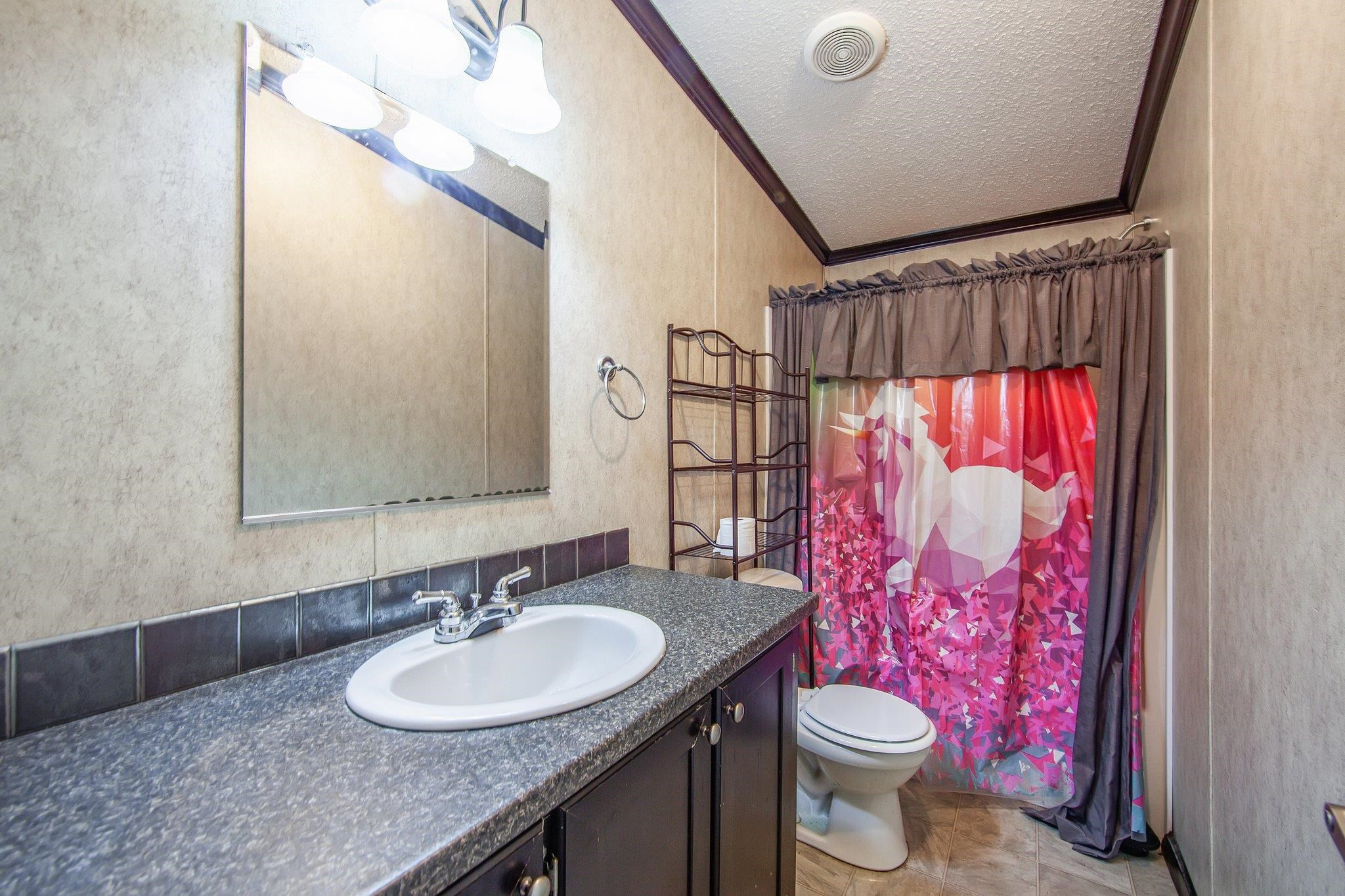 1040 River Road Bolivar, TN 38008 - Photo 6 of 27 a bathroom with a sink vanity mirror and toilet