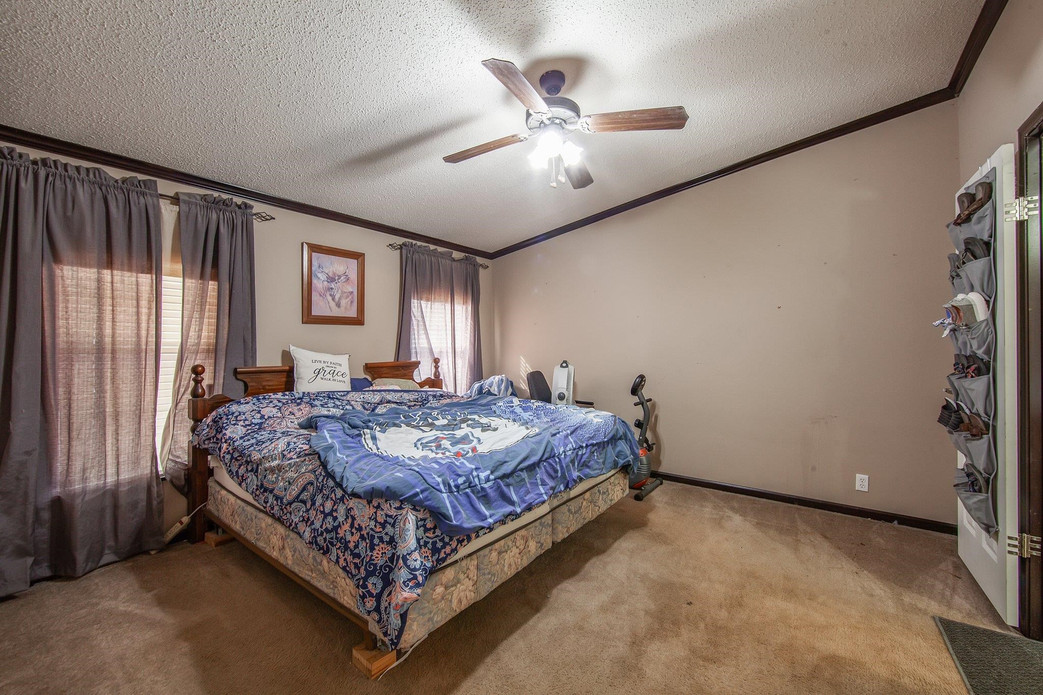1040 River Road Bolivar, TN 38008 - Photo 8 of 27 a bed sitting in a spacious bedroom next to a window and a chandelier
