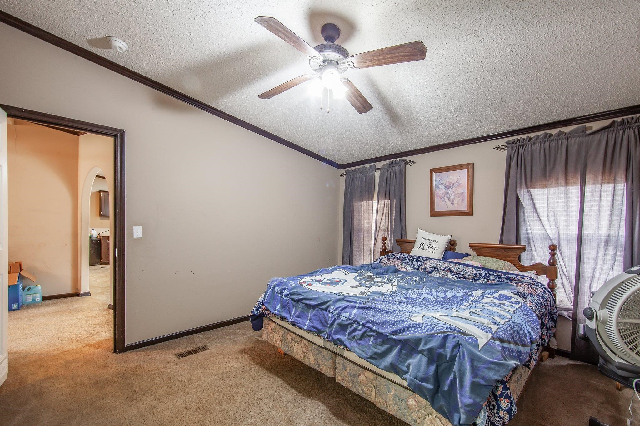 1040 River Road Bolivar, TN 38008 - Photo 9 of 27 a bedroom with a large bed and a chandelier