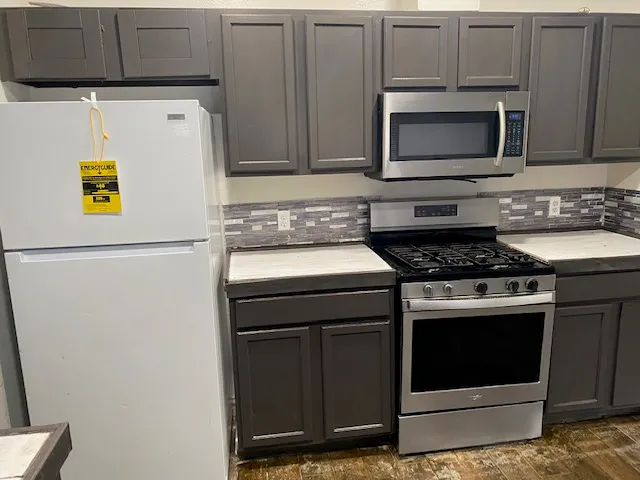 a kitchen with stainless steel appliances a stove a microwave and a refrigerator